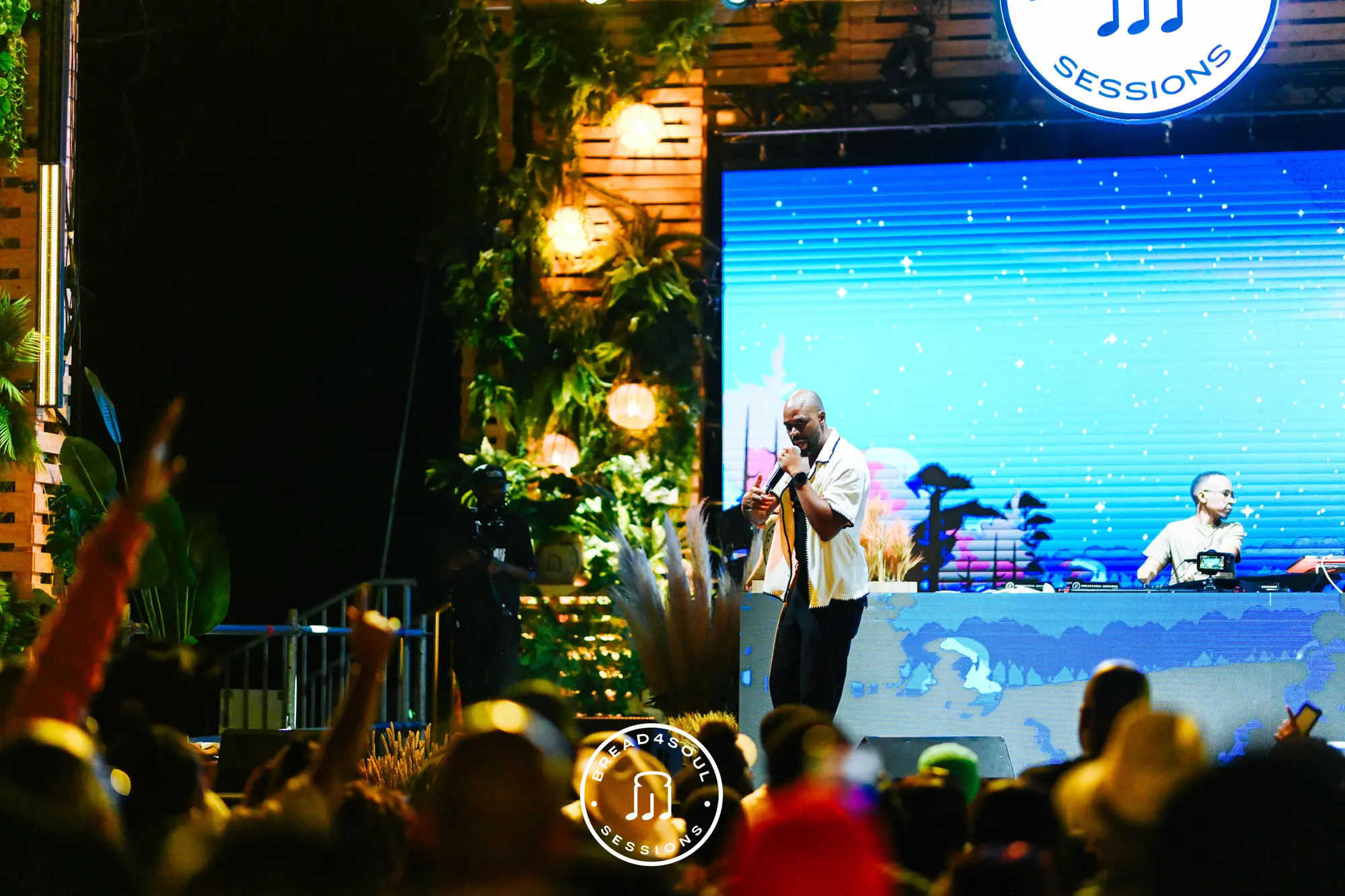Sanctuary — warm lanterns and lush greenery on stage